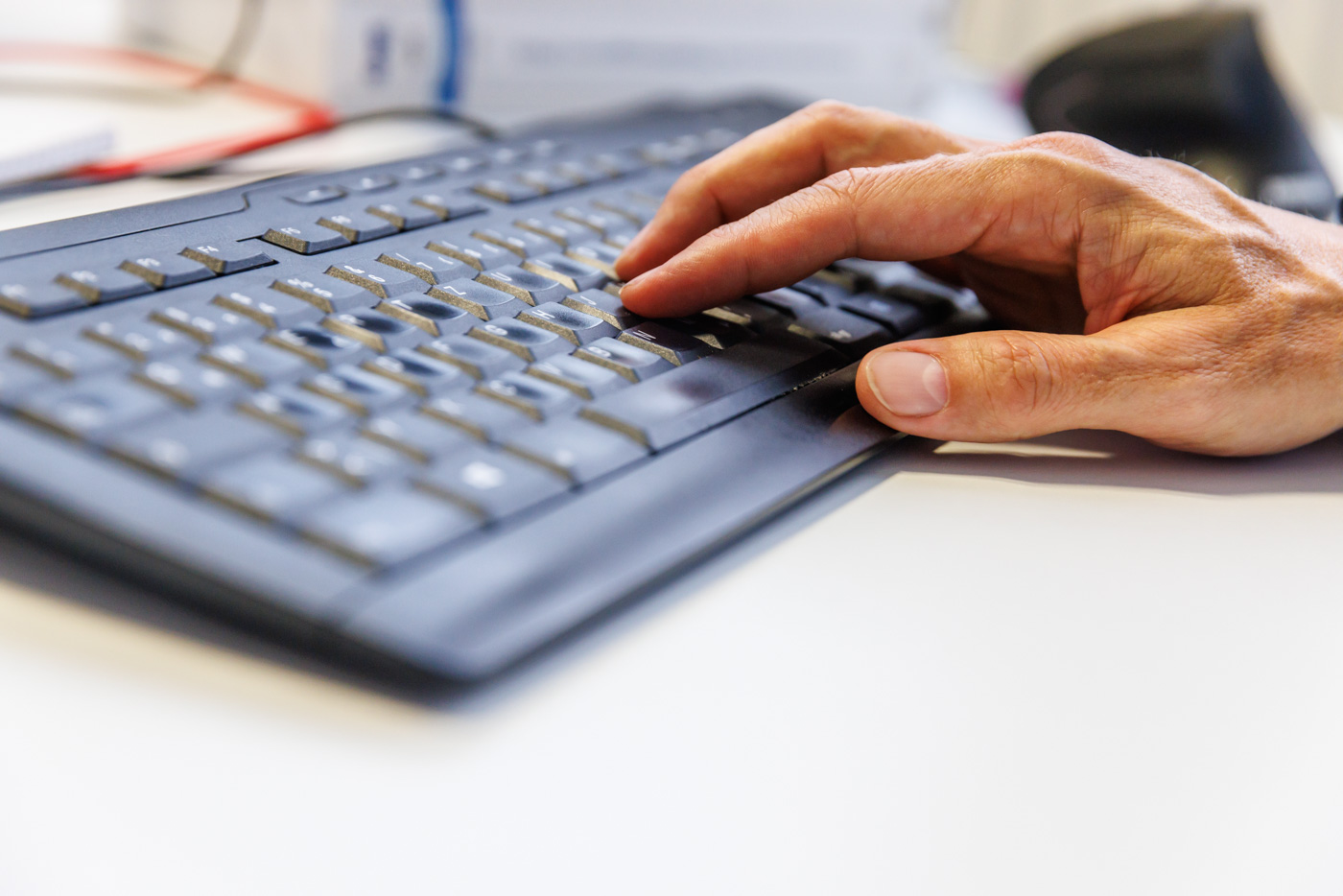 Foto: eine Hand liegt auf einer Tastatur
